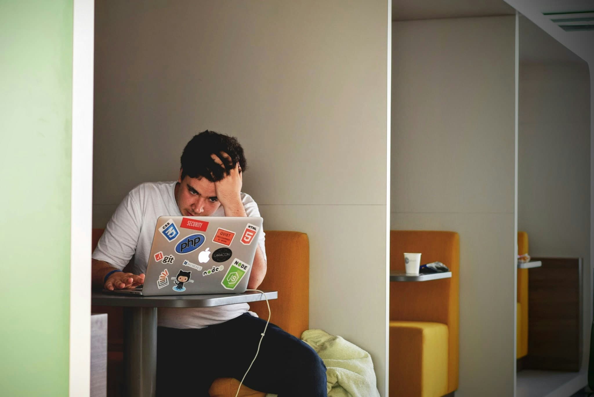 Man working at laptop with head in hands